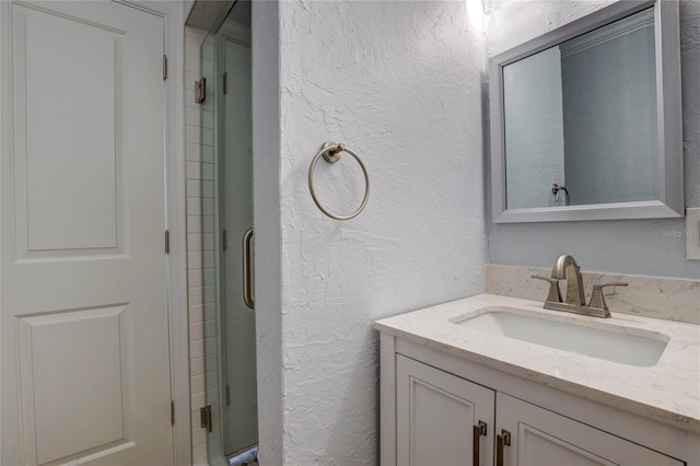 bathroom featuring large vanity and an enclosed shower