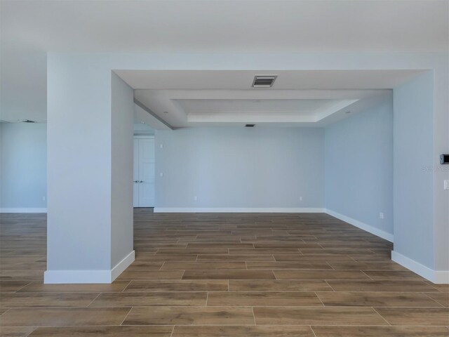 unfurnished room featuring dark hardwood / wood-style floors and a raised ceiling