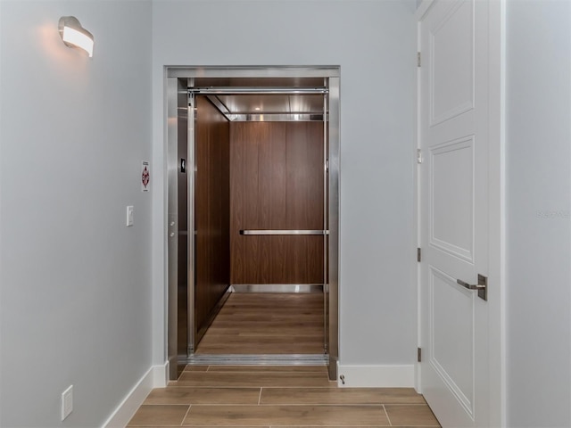 hall featuring elevator and light hardwood / wood-style floors