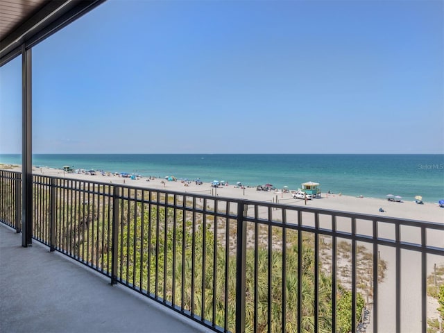 balcony featuring a view of the beach and a water view