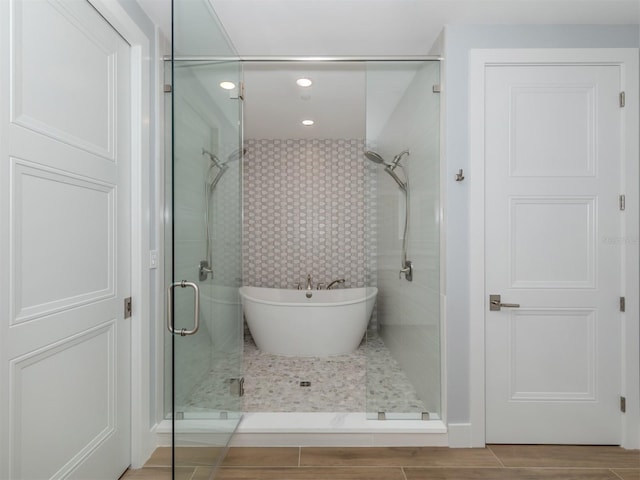 bathroom featuring hardwood / wood-style floors and plus walk in shower