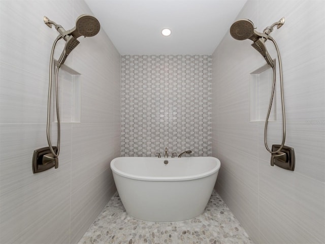 bathroom featuring a bathtub and tile walls