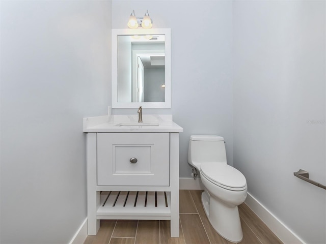 bathroom featuring toilet, vanity, and hardwood / wood-style flooring