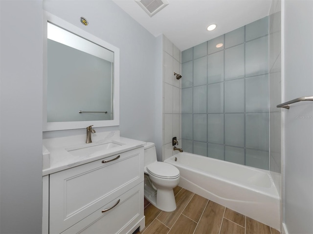 full bathroom with vanity, tiled shower / bath combo, and toilet