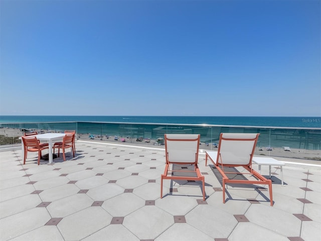 view of patio featuring a beach view and a water view