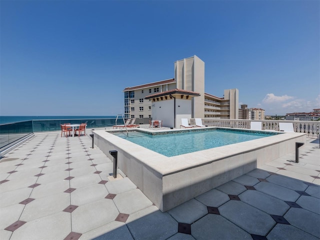 view of swimming pool with a water view and a patio