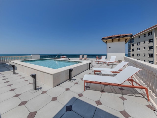 view of swimming pool with a water view and a patio