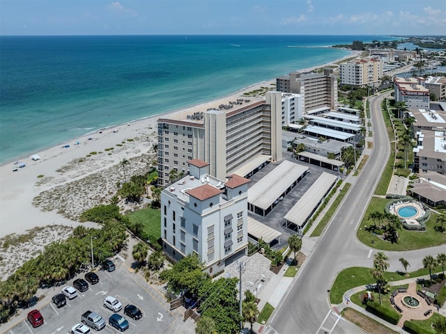 birds eye view of property featuring a water view and a beach view