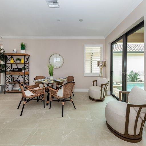 tiled dining space with crown molding and french doors