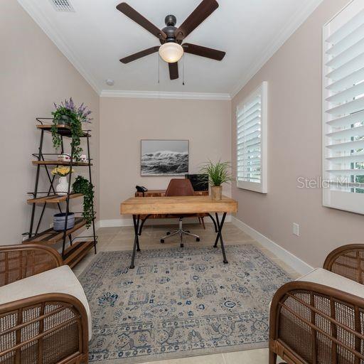 office area featuring tile patterned floors, ornamental molding, and ceiling fan