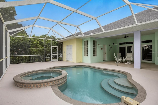 view of pool featuring ceiling fan, a patio area, an in ground hot tub, and glass enclosure