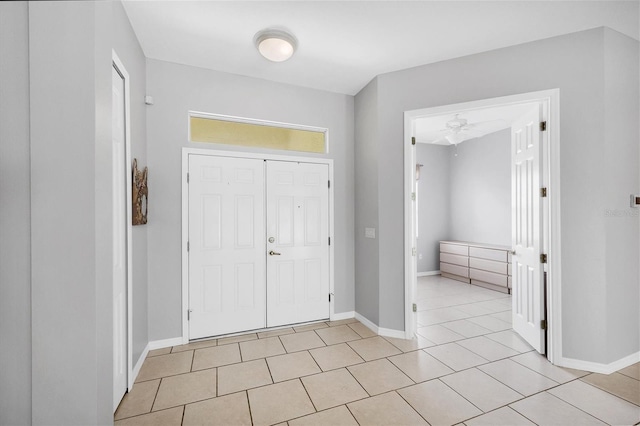 foyer entrance with ceiling fan and light tile patterned floors