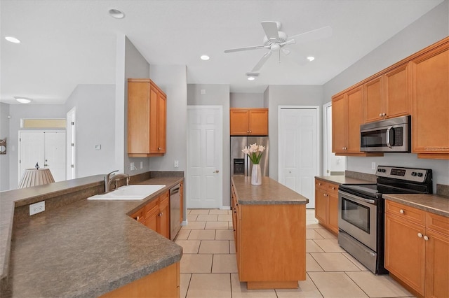 kitchen featuring light tile patterned flooring, appliances with stainless steel finishes, a kitchen island, and sink