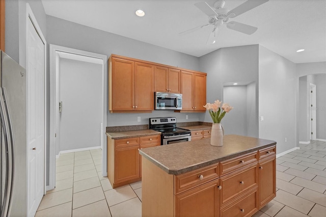 kitchen featuring ceiling fan, a kitchen island, light tile patterned floors, and appliances with stainless steel finishes