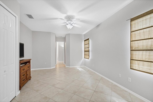 unfurnished living room with light tile patterned floors, plenty of natural light, and ceiling fan