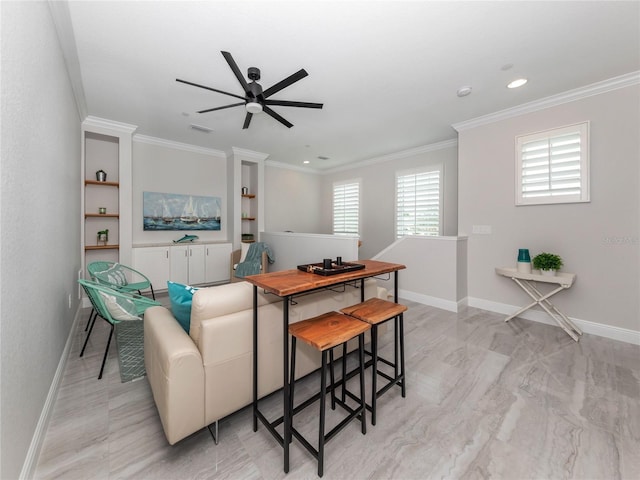 living room featuring built in shelves, crown molding, and ceiling fan