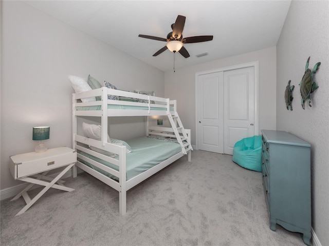 carpeted bedroom featuring a closet and ceiling fan