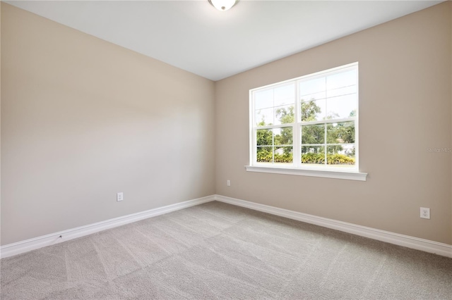 unfurnished room with carpet floors and baseboards