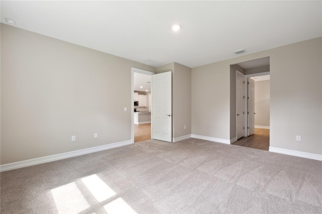 unfurnished bedroom featuring baseboards, recessed lighting, visible vents, and light colored carpet