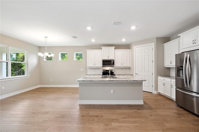 kitchen with appliances with stainless steel finishes, white cabinets, visible vents, and light wood-style flooring