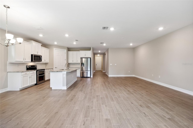 kitchen featuring visible vents, light wood-style flooring, appliances with stainless steel finishes, open floor plan, and an inviting chandelier