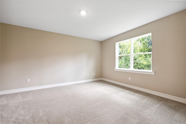 carpeted empty room with baseboards