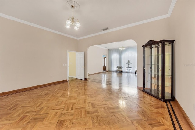 spare room featuring light parquet floors, crown molding, and a notable chandelier