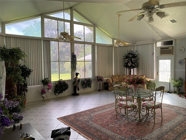 sunroom / solarium with ceiling fan, a healthy amount of sunlight, vaulted ceiling, and an AC wall unit