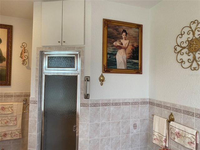 bathroom with tile walls and an enclosed shower