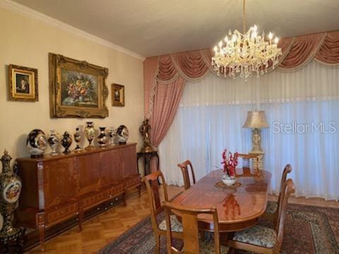 dining space with an inviting chandelier, parquet floors, and crown molding