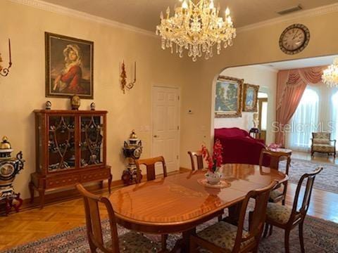 dining room with parquet floors, crown molding, and a chandelier