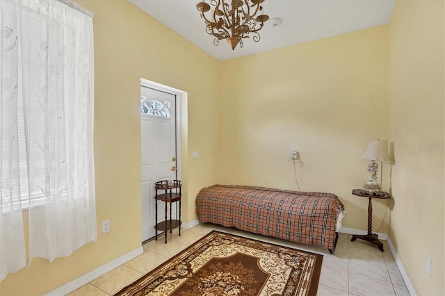 bedroom with light tile patterned floors and a chandelier