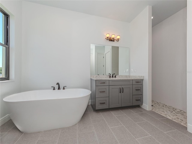 bathroom featuring a healthy amount of sunlight, tile floors, and vanity with extensive cabinet space