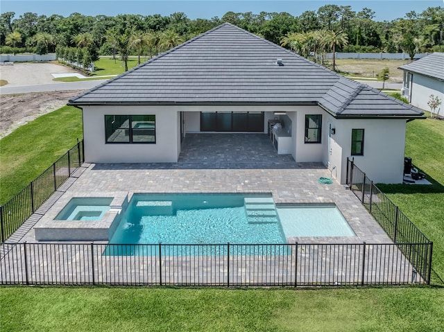 back of property featuring a patio, a yard, and a swimming pool with hot tub