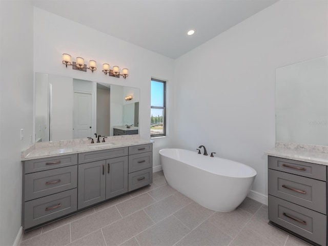 bathroom featuring a tub, oversized vanity, and tile flooring