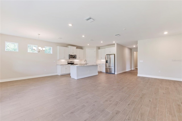 unfurnished living room with light wood-type flooring, sink, and a chandelier