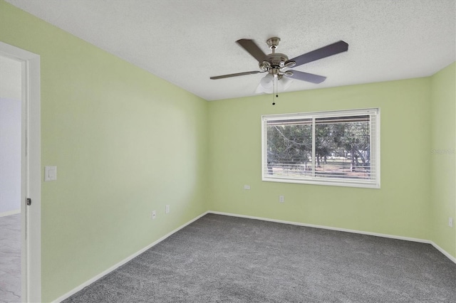 spare room featuring carpet, ceiling fan, and a textured ceiling