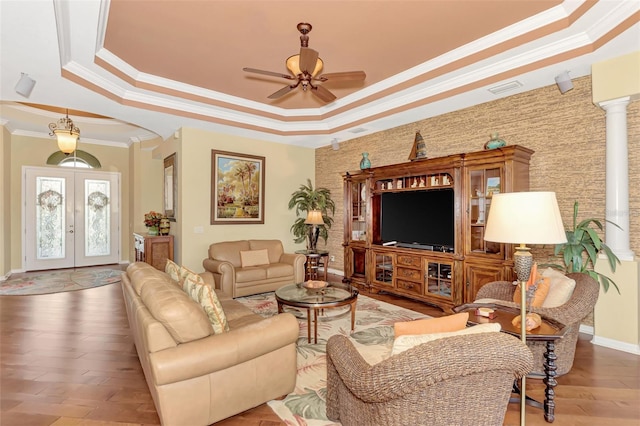 living room featuring hardwood / wood-style floors, french doors, a raised ceiling, crown molding, and ceiling fan