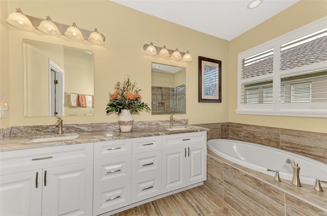 bathroom featuring vanity and a relaxing tiled tub