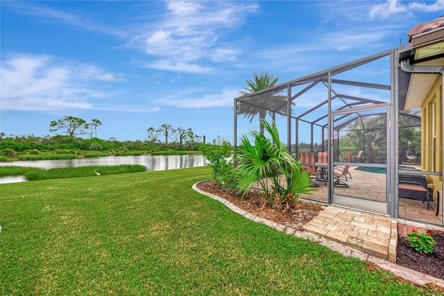 view of yard with glass enclosure, a water view, and a patio