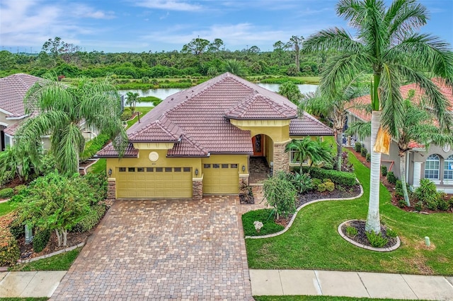 mediterranean / spanish-style home featuring a water view, a front yard, and a garage