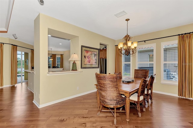 dining space featuring hardwood / wood-style floors and a chandelier