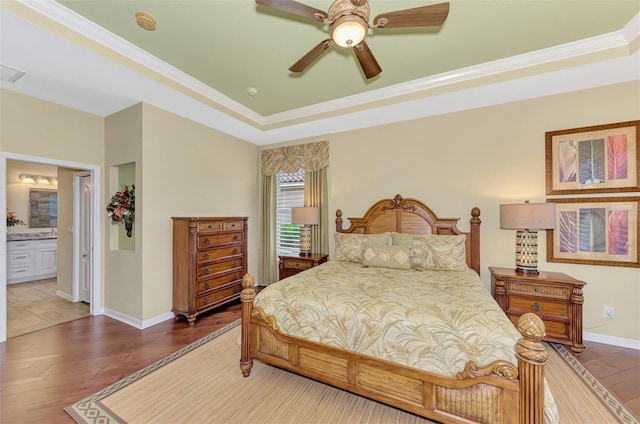 bedroom with connected bathroom, ceiling fan, crown molding, and dark wood-type flooring