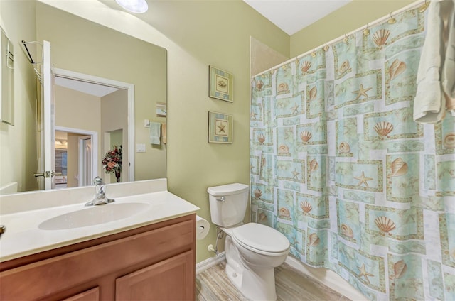 bathroom featuring walk in shower, hardwood / wood-style flooring, vanity, and toilet