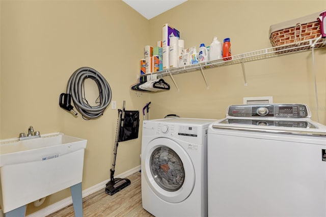 washroom featuring sink, light hardwood / wood-style floors, and independent washer and dryer