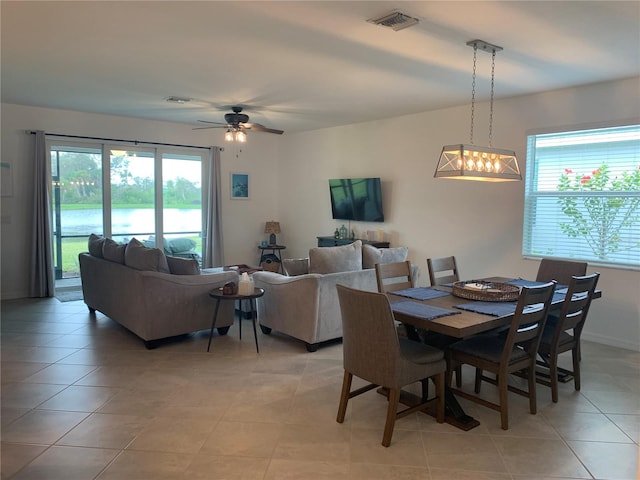 dining room with ceiling fan with notable chandelier and light tile floors