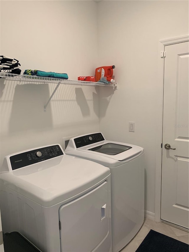 washroom featuring light tile floors and washing machine and clothes dryer