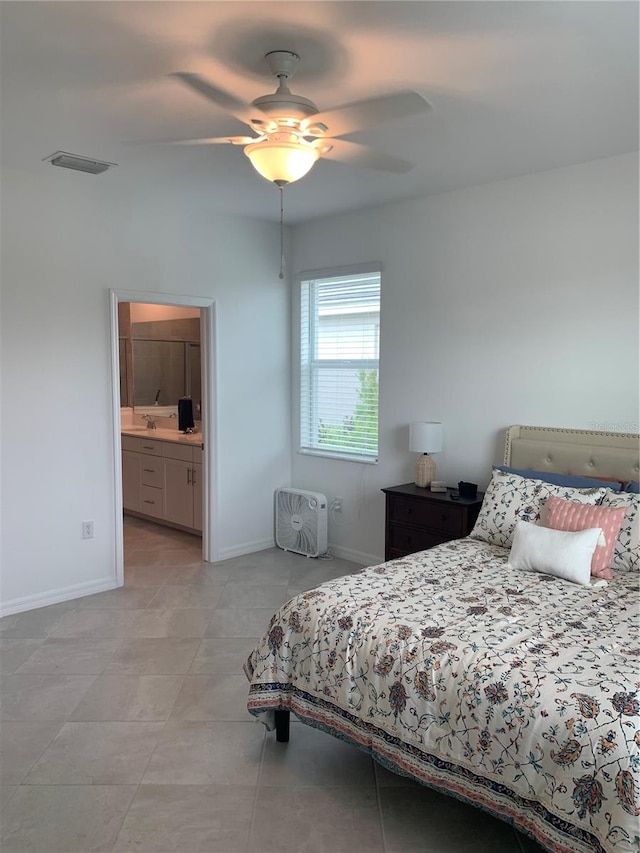 tiled bedroom featuring sink, ceiling fan, and ensuite bathroom