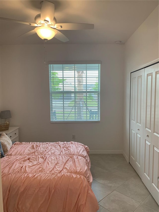 bedroom featuring a closet, ceiling fan, and light tile floors