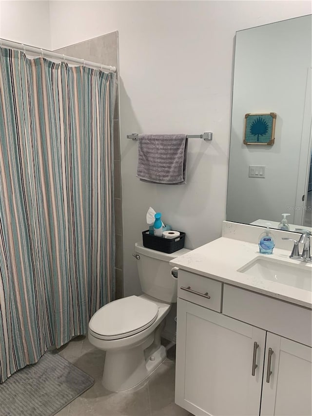 bathroom featuring oversized vanity, toilet, and tile floors